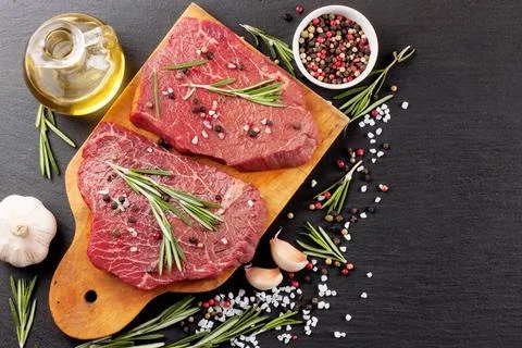 Raw beef steak with spice Stock Photos