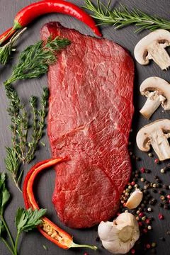 Raw beef steak with spices and herbs Stock Photos