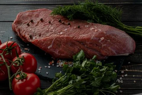 Raw beef steak with spices on a dark slate, stoneselective focus Foto stock