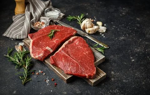 Raw beef steak with spices. Stock Photos