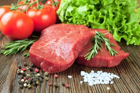 Raw beef steak with vegetables and spices Stock Photos