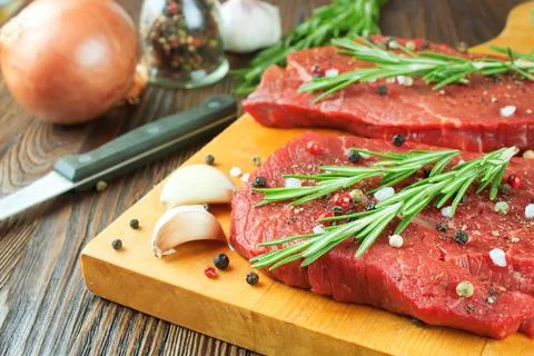 Raw beef steak with vegetables and spices Stock Photos