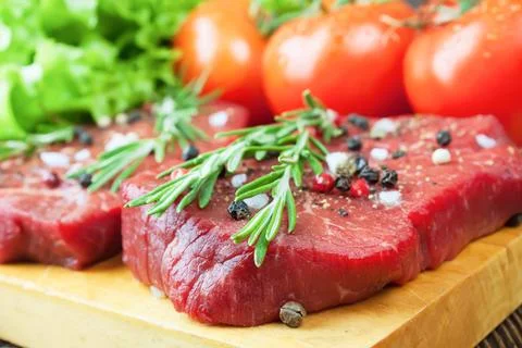 Raw beef steak with vegetables and spices Stock Photos