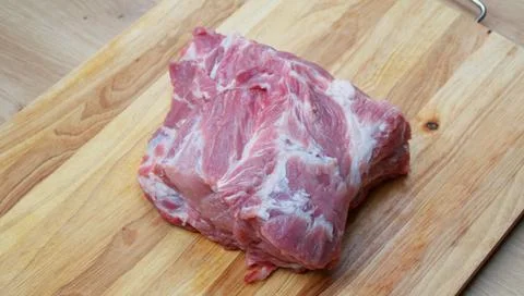 Raw beef steak with visible fat marbling on a wooden cutting board Stock Photos