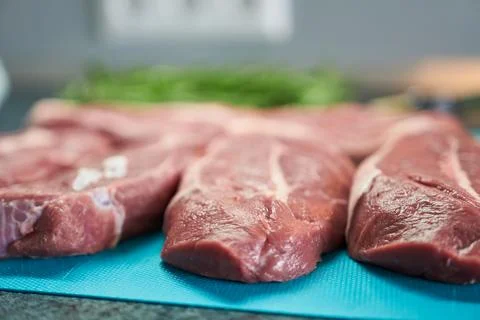 Raw beef steaks on a cutting board, ready for cooking. Selective focus. Stock Photos