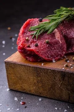 Raw beef steaks with salt pepper and rosemary. Fotos de archivo