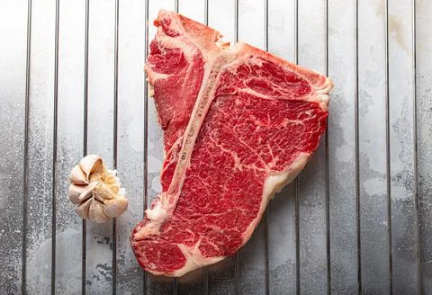 Raw beef T-bone steak on aluminum tray from above Stock Photos