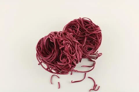 Raw beetroot noodles on white background with copy space Stock Photos