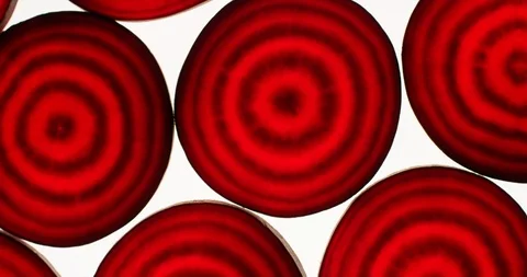 Raw beetroot slices rotating on a bright white background. Close up top view Stock Footage 107951763