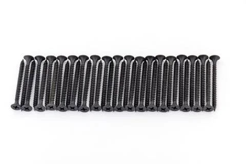 A raw of black average size screws on white background Stock Photos