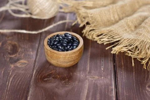 Raw black turtle beans on brown wood Stock Photos