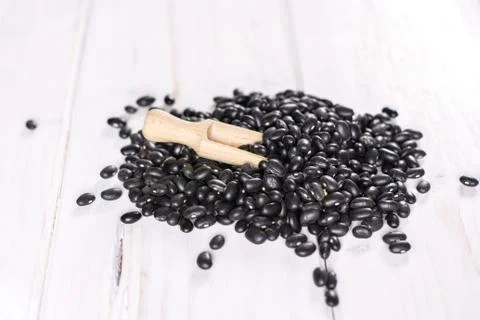 Raw black turtle beans on grey wood Foto stock