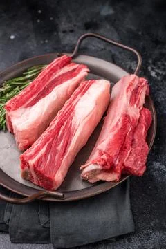 Raw bone-in beef short ribs ready for cooking, garnished with rosemary spri.. Stock Photos