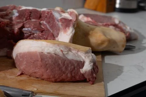 Raw bone-in pork leg deboning in a home kitchen - authentic butcher stock, .. Stock Photos