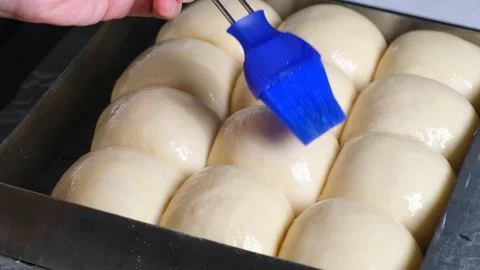 Raw bread and apply butter on top by using kitchen brush with melted butter Stock Footage 128594434