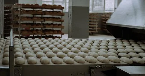 Raw bread is making on the automatic equipment line in the bakery Stock Photos