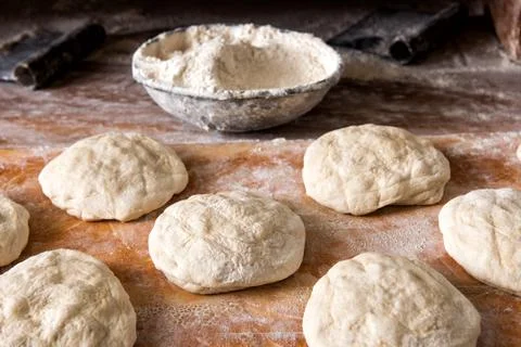 Raw bread Rising on Table with Bowl of Flour Stock Photos
