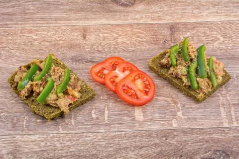 Raw bread with a spread decorated with pepper and tomatoes Stock-Fotos