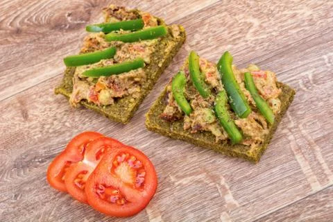 Raw bread with a spread decorated with pepper and tomatoes Stock Photos