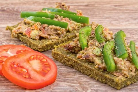Raw bread with a spread decorated with pepper and tomatoes Stock Photos