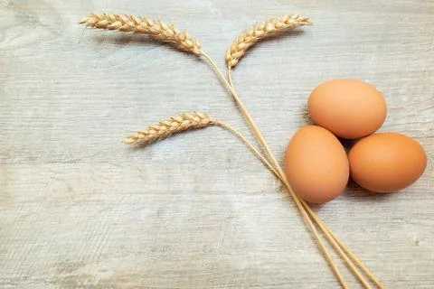 Raw brown chicken eggs with spikelets on a wooden table. Easter rustic concep 스톡 사진