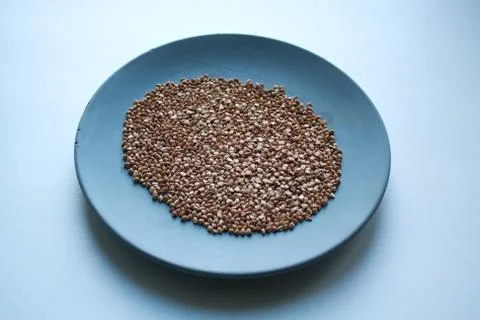 Raw buckwheat on plate Stock Photos
