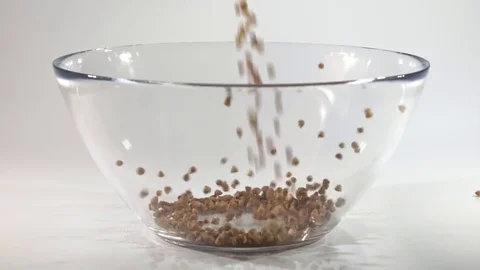 Raw buckwheat is poured into a bowl. Stock Footage 80676239