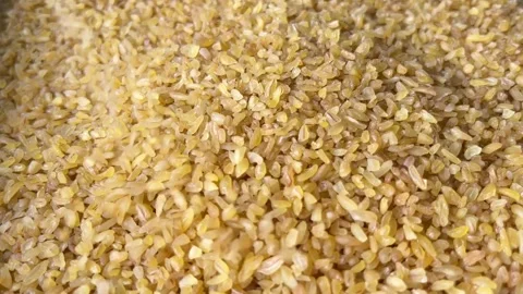 Raw bulgur wheat groats falling down. Horizontal Stock Footage 336506919