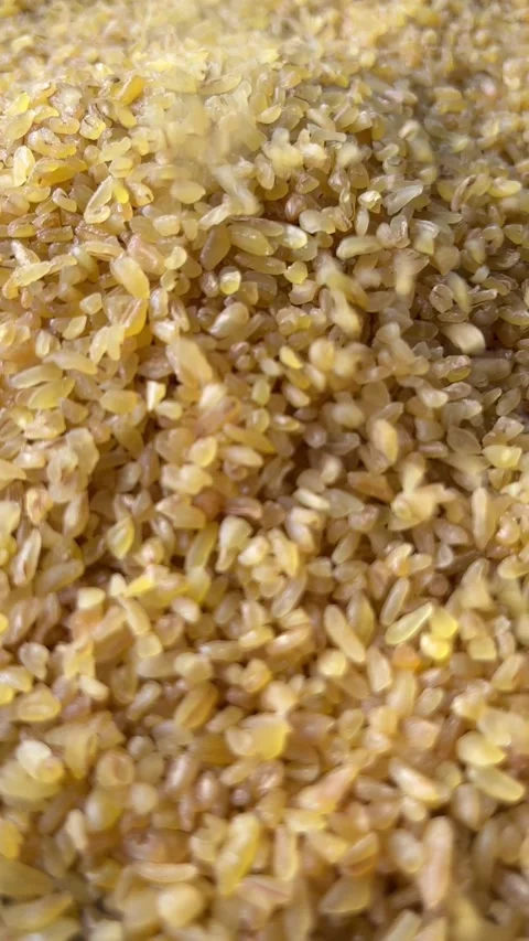 Raw bulgur wheat groats falling down. Vertical Stock Footage 336506920