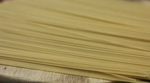 Raw bunch of spaghetti on a wooden board closeup Stock Footage 62473450