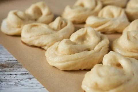 Raw buns on baking paper, close-up, selective focus Stock Photos