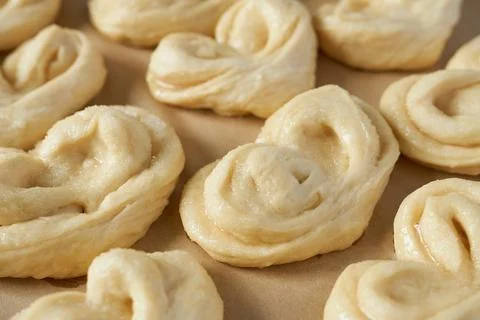 Raw buns on a baking sheet, close-up. Stock Photos