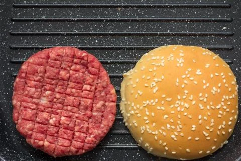 Raw burger in grill pan Stock Photos