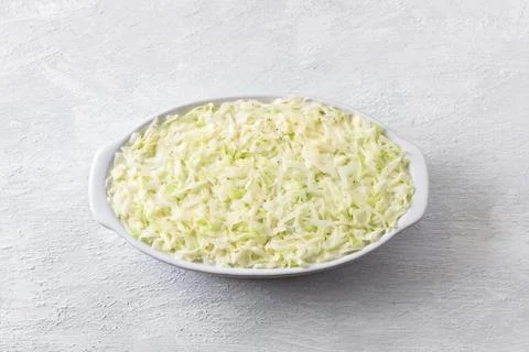 Raw cabbage casserole in a baking dish on a light gray background Stock Photos