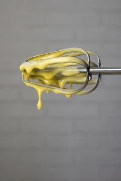 Raw cake dough dripping down from mixer beaters Stock Photos