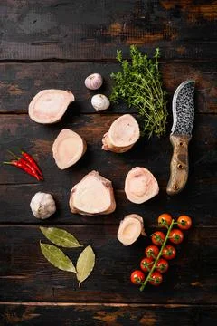 Raw calf bones, on old dark wooden table background, top view flat lay Foto stock