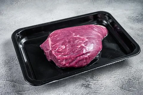 Raw cap rump steak or top sirloin beef meat steak in vacuum packaging. White Stock Photos