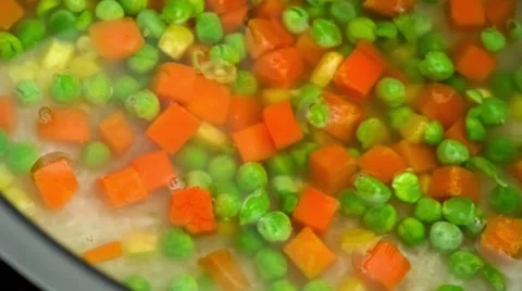 Raw carrots, peas, corn and white rice covered with water and combined togeth Stock Footage 62794533