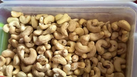 Raw cashew nuts close up in transparent container with natural creamy texture Stock Footage 345723720