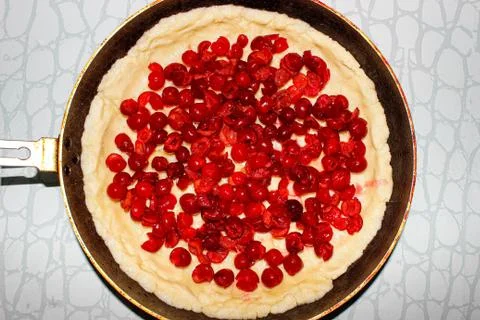Raw cherry pie made from shortbread dough in a baking dish. Stock Photos