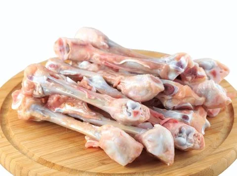 Raw chicken bones on white background on a wooden board Stock Photos
