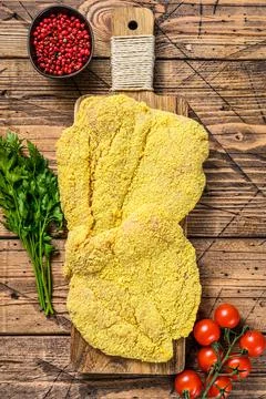 Raw chicken Breaded Weiner Schnitzel. Wooden background. Top view Stock Photos