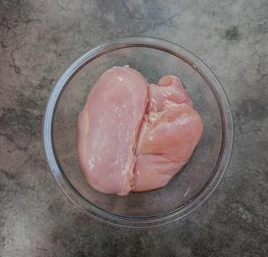 A raw chicken breast on a grey background Stock Photos