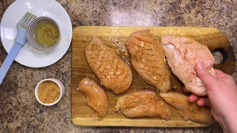 Raw chicken breasts are turned over to the other side for further cooking.  Stock-Footage 321152608