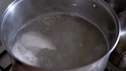 Raw Chicken Breasts Boiling in Water Inside Metal Pot for Homemade Soup Stock-Footage 338999279