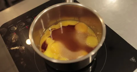 Raw chicken eggs are broken into a metal bowl on the table Stock Footage 256981807