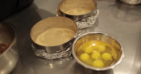 Raw chicken eggs are broken into a metal bowl on the table Stock Footage 256982037