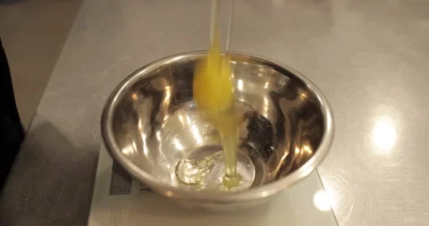 Raw chicken eggs are broken into a metal bowl on the table Stock Footage 256982908