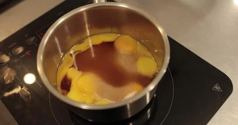 Raw chicken eggs are broken into a metal bowl on the table of a professiona.. Stock Photos