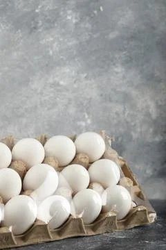 Raw chicken eggs in egg box on a marble background Stock Photos